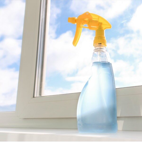 dispencer spray multiuso per la pulizia dei vetri poggiato su finestra
