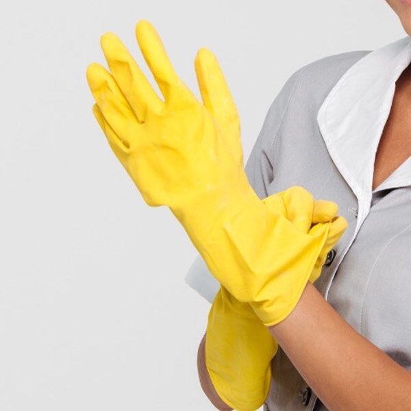 donna che indossa guanti gialli per la pulizia degli ambienti