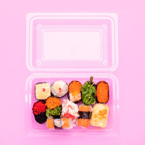 confezione asporto in plastica aperta vista dall'alto contenente sushi